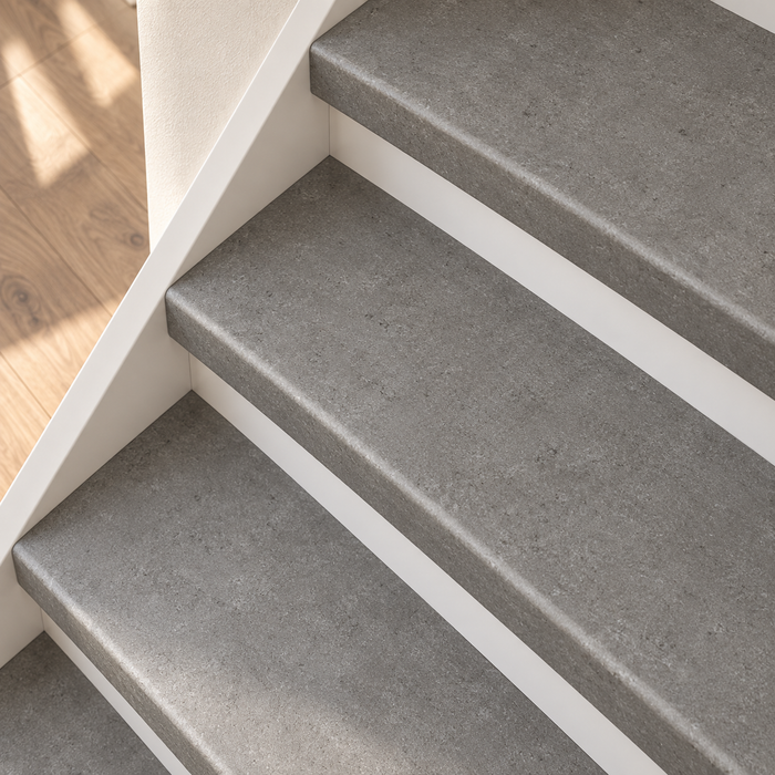 beton traprenovatie, dichte trap met witte stootborden, detail schuin van boven