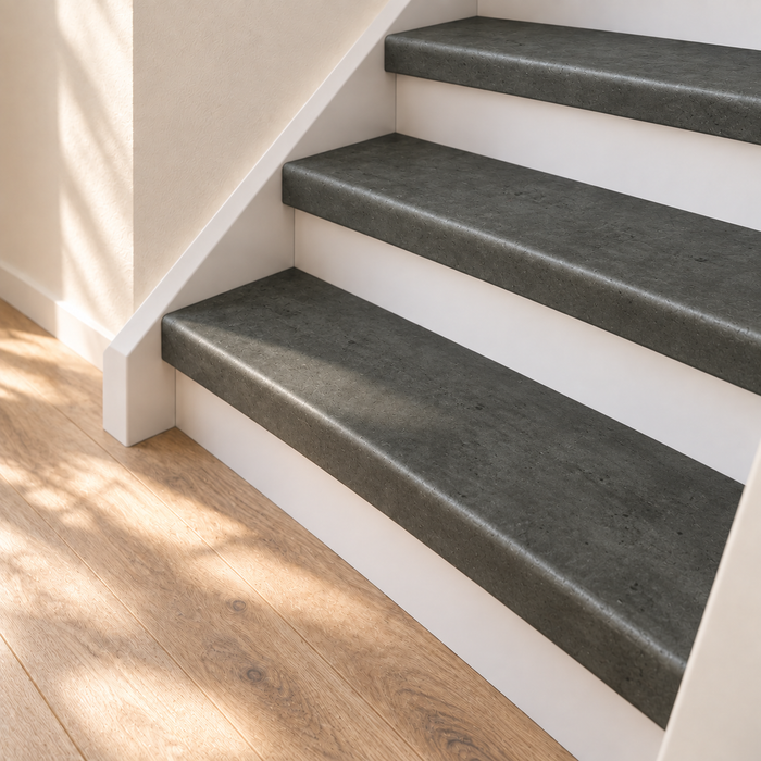 beton grijs traprenovatie, dichte trap met witte stootborden, detail van de onderste treden