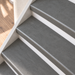 loft grijs traprenovatie, dichte trap met witte stootborden, detail schuin van boven