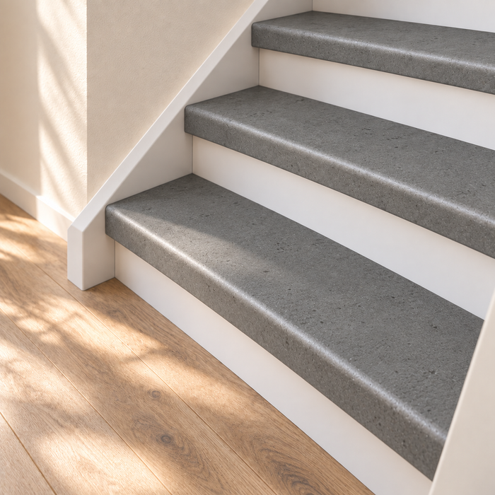 loft grijs traprenovatie, dichte trap met witte stootborden, detail van de onderste treden